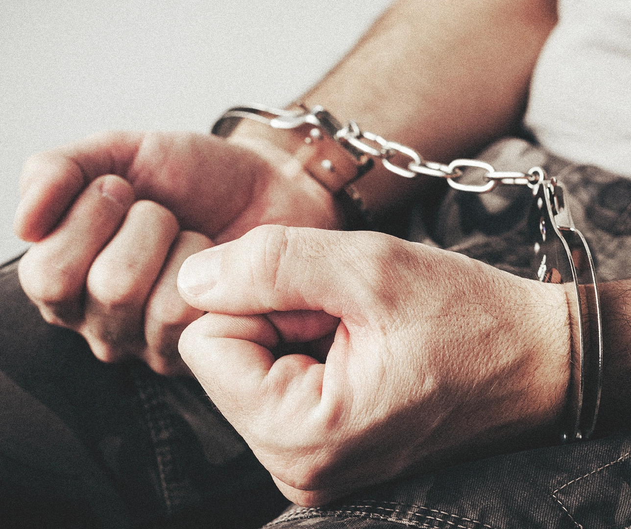 Imagen de una persona con unas esposas y está detenido.